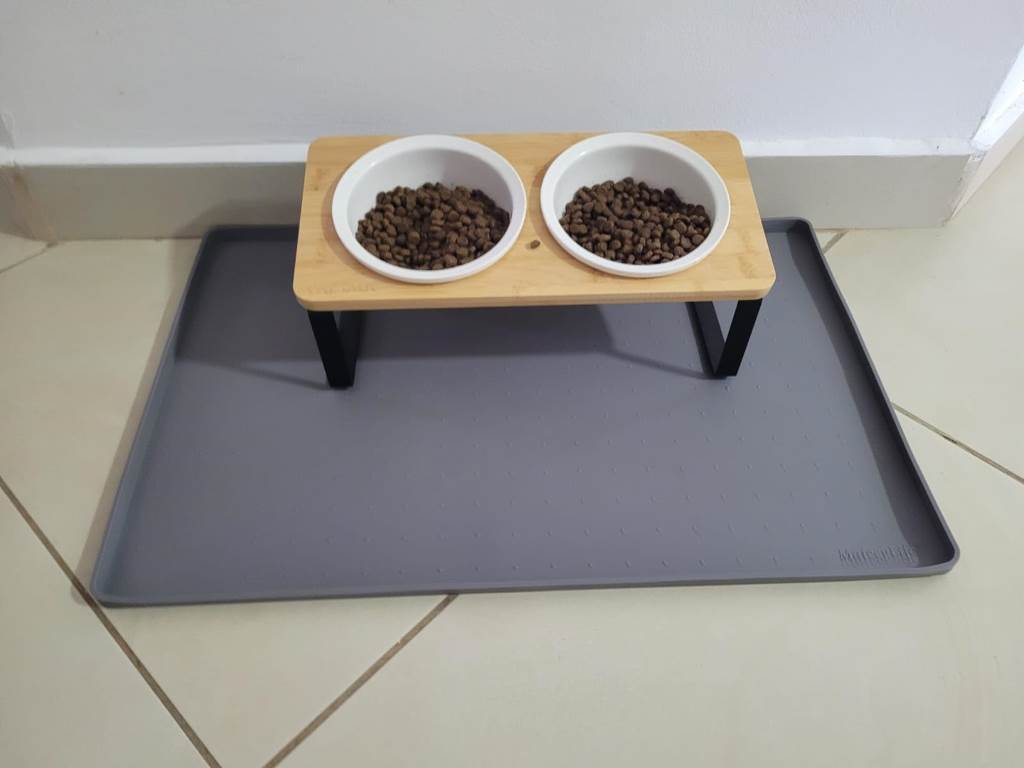Close-up of MateeyLife silicone pet food mat catching kibble spills on kitchen floor